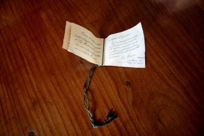 Open booklet with decorative string detailing a lampadario a sospensione di la murrina design italiano con ottone firmato
