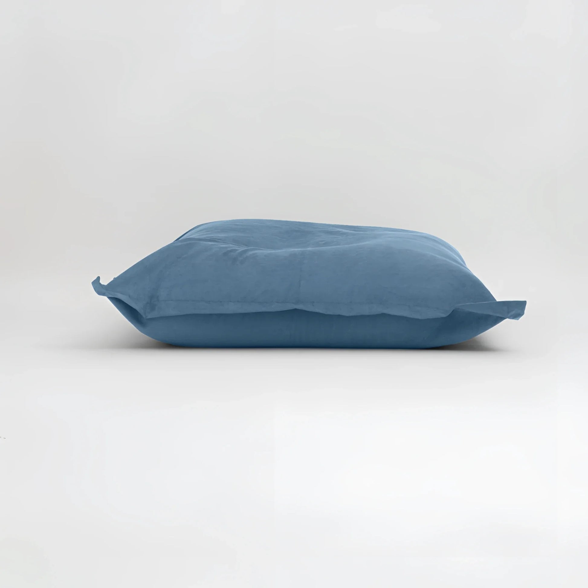 Maxi cuscino firenze in colore blu solido con superficie in tessuto leggermente stropicciato e dimensioni generose