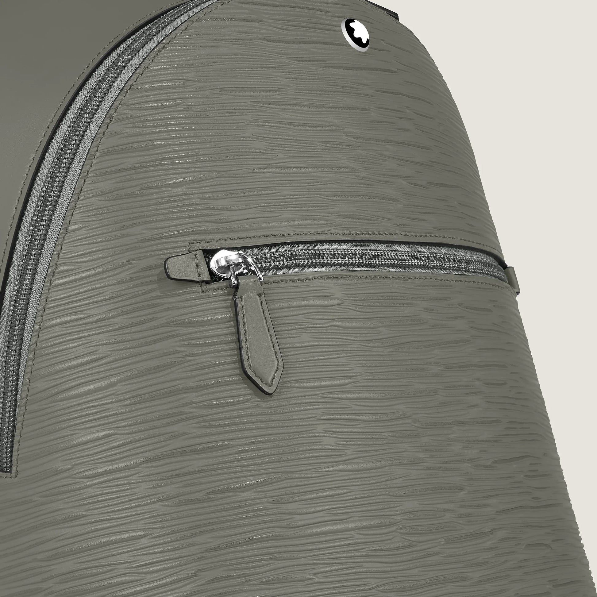 Zaino mini montblanc in pelle grigio medio con cerniera argentata e logo circolare elegante sul davanti